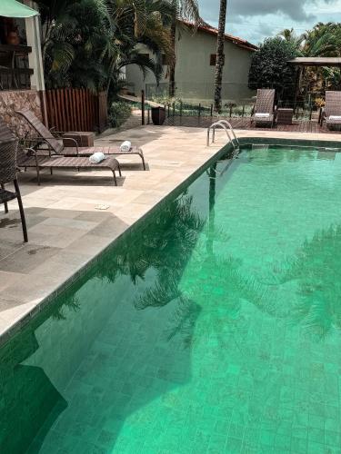 a swimming pool with green water in a yard at Pousada Recanto da Grande Paz in Alto Paraíso de Goiás