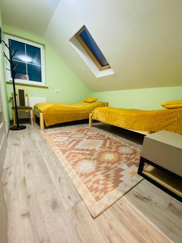 a room with two beds and a rug at Chata Nova in Milejczyce