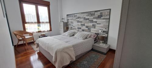a bedroom with a bed and a brick wall at Apartamento Mar in Bádames