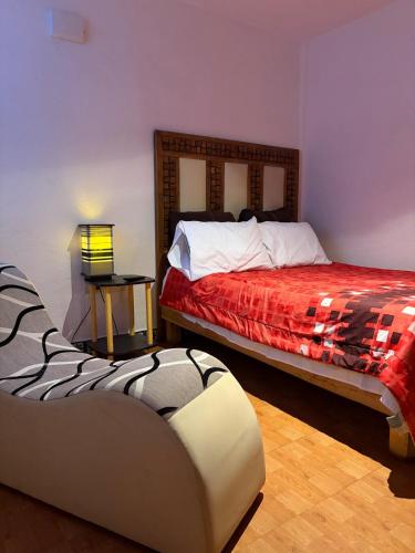 a bedroom with a bed and a couch in it at Tantra 1 - 24hrs in Cholula