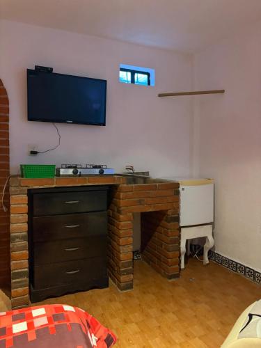 a living room with a flat screen tv on the wall at Tantra 1 - 24hrs in Cholula