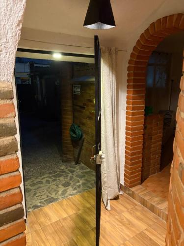 an open door to a room with a brick wall at Tantra 1 - 24hrs in Cholula