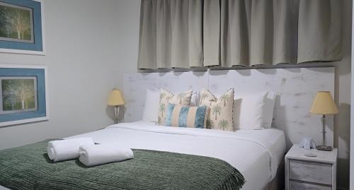 a bedroom with a large white bed with pillows at Ocean Retreat in Yeppoon