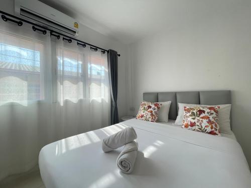 a bedroom with a large white bed with a window at Royal BJ Hotel in Pattaya South