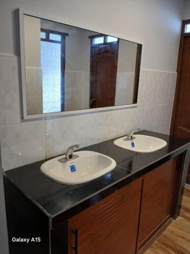 a bathroom with two sinks and a large mirror at Qamana Soto S in Uyuni