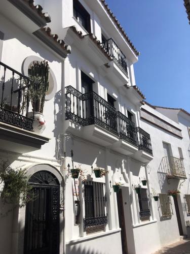 a white building with balconies and plants on it at Casa Suspiro in Estepona