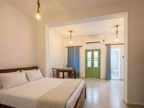 a bedroom with a bed with a green door at Stara Weligama in Weligama