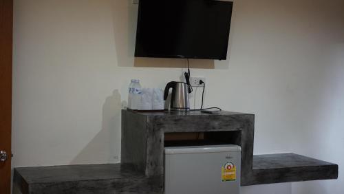 a room with a television and a small refrigerator at The Miracle Guesthouse & Diving in Koh Tao