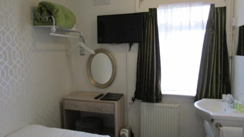 a small bathroom with a mirror and a sink at The Scala Hotel in Blackpool