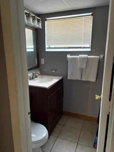 a bathroom with a sink and a toilet and a mirror at OCEANS 735 of DEERFIELD BEACH in Deerfield Beach