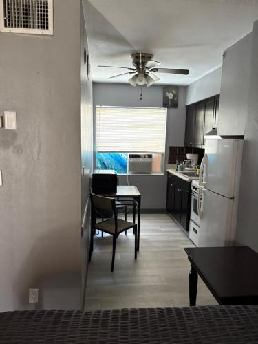 a kitchen with a table and a white refrigerator at OCEANS 735 of DEERFIELD BEACH in Deerfield Beach