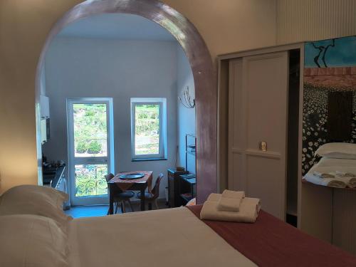 a bedroom with a bed and a table and a window at Scaglie di Mare in Manarola