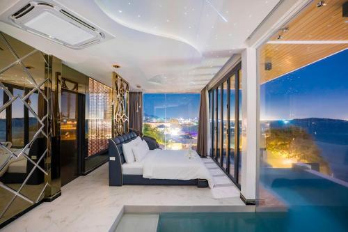 a bedroom with a bed and a view of a city at Madusea Grand Villa มาดูซี แกรนด์ วิลล่า in Ko Larn