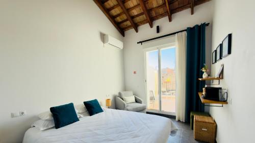 a bedroom with a bed and a chair and a window at Casa Sibarita in Rafelguaraf