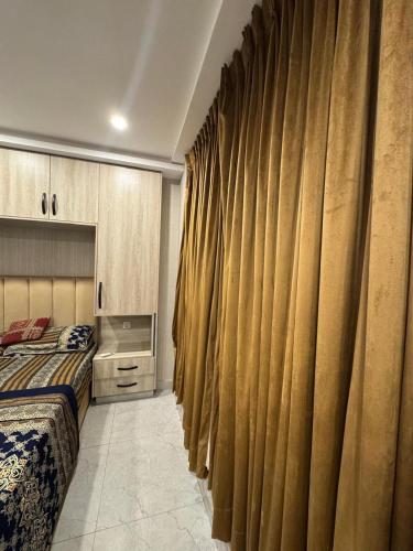 a bedroom with a bed and some curtains at Stayease in Lahore