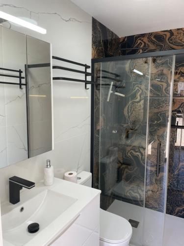 a bathroom with a sink and a glass shower at Ferienhaus direkt am Strand mit Terrasse und Meerblick in Torrevieja in Punta Prima
