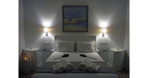 a bedroom with a white bed with two books on it at Pier's House in Pollonia