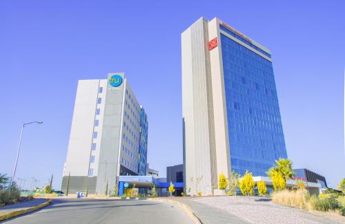 a large building with a sign on it next to a street at Tru By Hilton Puebla Angelopolis in Puebla