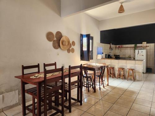 a dining room with a table and chairs and a kitchen at Mini Hostel no centro de Tutoia in Tutóia