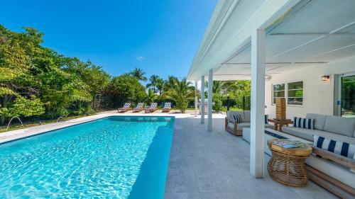 a swimming pool next to a house at Tranquility Villa Heated Pool & Lanai in Jupiter