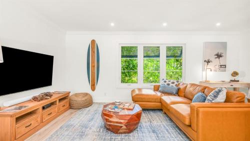 a living room with a couch and a flat screen tv at Tranquility Villa Heated Pool & Lanai in Jupiter