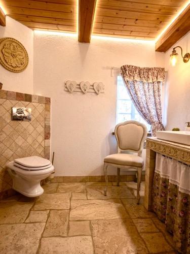 a bathroom with a toilet and a chair and a sink at Nasze Chabazie in Olszyna