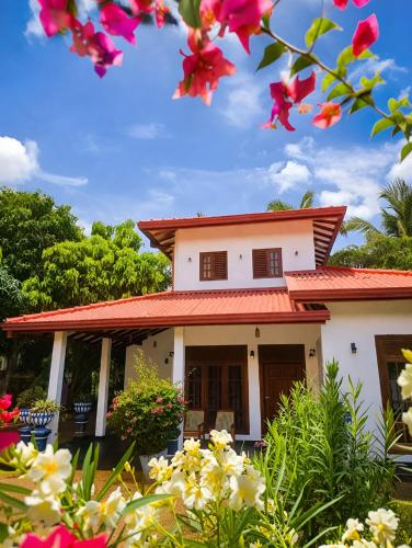 a house with flowers in front of it at Udara Guest - Yala Safari in Yala