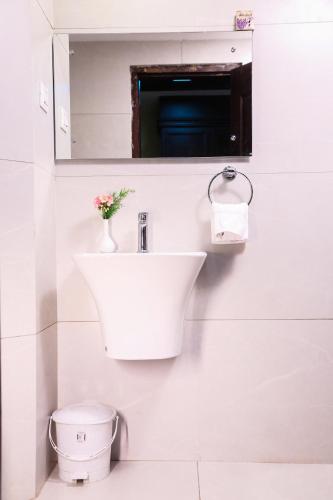 a white bathroom with a sink and a toilet at Hotel Preethi Classic Towers in Ooty