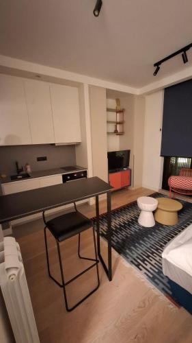 a living room with a table and a kitchen at Belgrade Waterfront Lux Studio Apartment in Belgrade