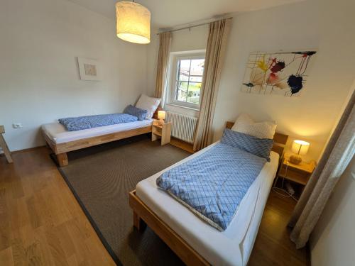 a room with two beds and a window at Ferienwohnung Straußstrasse in Bayerisch Gmain