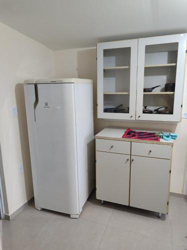 a white refrigerator and a cabinet in a room at Kitnet 03 Lunardi Campinas in Campinas
