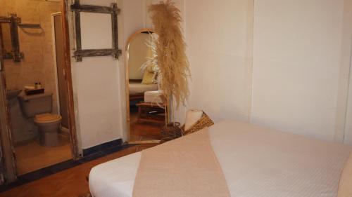 a bedroom with a bed and a mirror and a bathroom at Marazao Beach Hotel & Wellness in Tierra Bomba