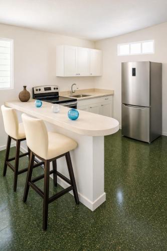 a kitchen with a counter and a refrigerator at Dorado Costa De Oro Beach 2 Bedroom Oceanfront by Rentalspr in Dorado