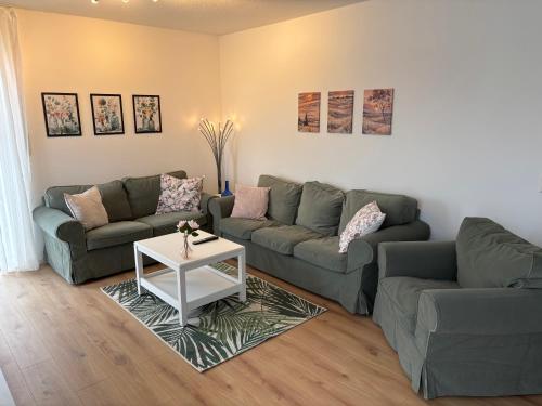 a living room with two couches and a table at Ferienwohnung Heinrichshofen in Heinrichshofen