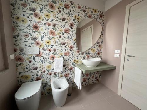 a bathroom with a toilet and a sink and a mirror at Appartamento Ideal con piscine e animazione Hotel Alba d Oro estate in Gatteo a Mare