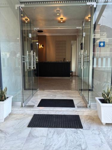 a lobby with a glass door and two black mats at Therma Hotel in Loutra Ipatis