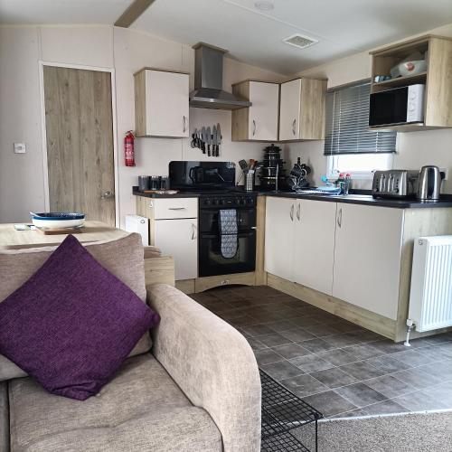 a living room with a couch and a kitchen at Home from home in Hastings