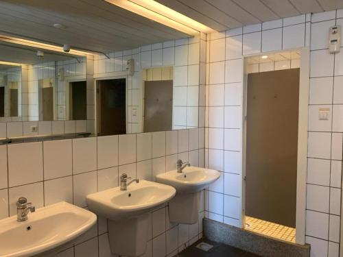 a bathroom with two sinks and two mirrors at Lakes Small in Kaag