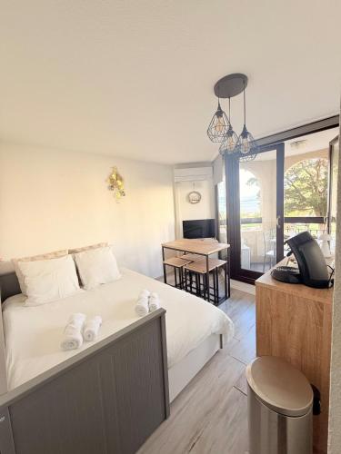 a bedroom with a bed and a desk with a phone at Terrasse vue Etang, piscine Séjour détente in Le Barcarès