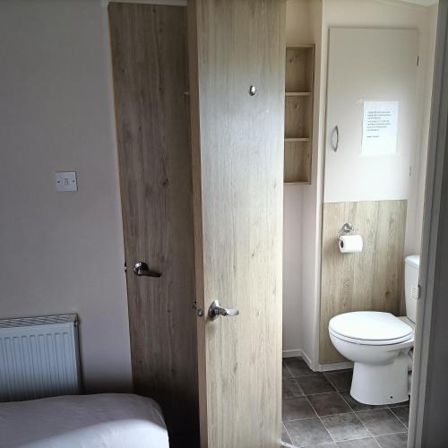 a bathroom with a toilet and a wooden door at Home from home in Hastings