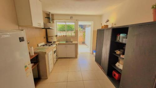 a kitchen with a white refrigerator and a tile floor at Depto Diucon Centro in Esquel