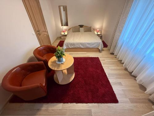 a bedroom with a bed and a table and chairs at Ramybes sala in Palanga