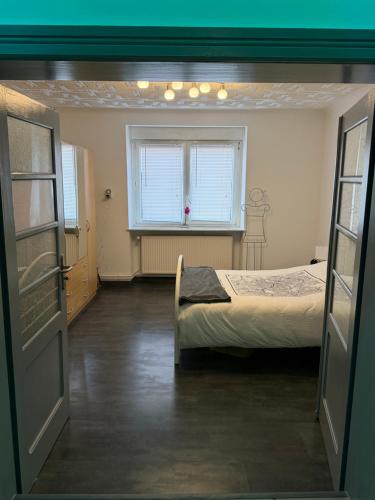 a room with two beds and a window at La Parenthèse coté Saar in Wittring