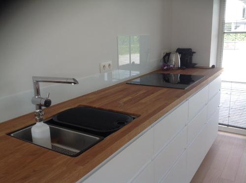 a kitchen with a sink and a wooden counter top at l'Intervalle in Mont-Saint-Guibert