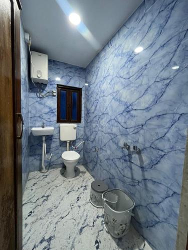 a blue marble bathroom with a toilet and a sink at Hotel Golden Palace in Chhatarpur