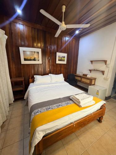 a bedroom with a bed with a ceiling fan at 喜悦民宿 Joy in Luang Prabang
