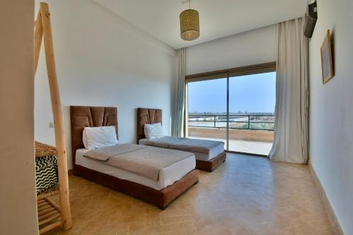 a bedroom with two beds and a large window at Dar Sofia Villa in Marrakesh