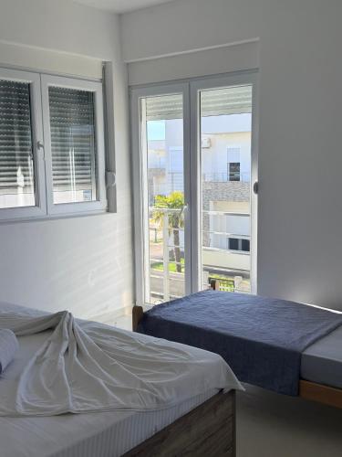 a bedroom with two beds and two windows at Veloura in Ulcinj