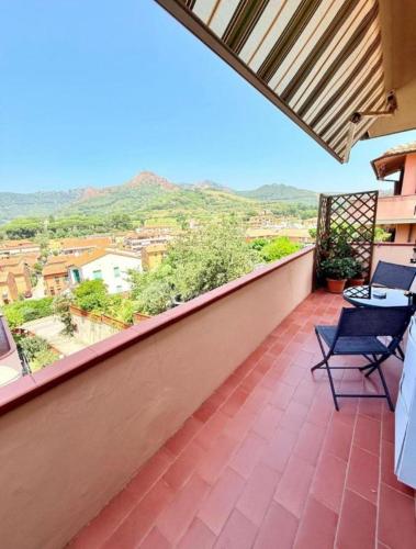 a balcony with chairs and a view of the mountains at Isabel Apartment in Porto Azzurro