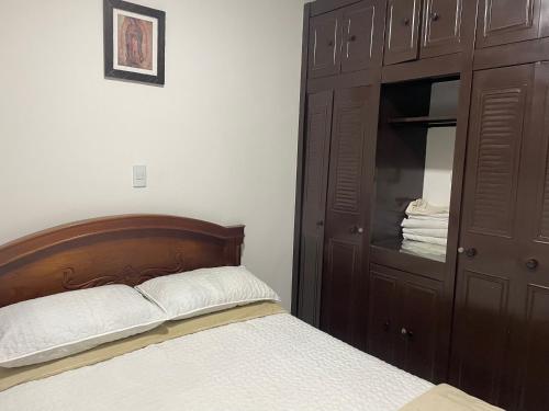 a bedroom with a bed and a wooden cabinet at Casa Roldanillo in Roldanillo